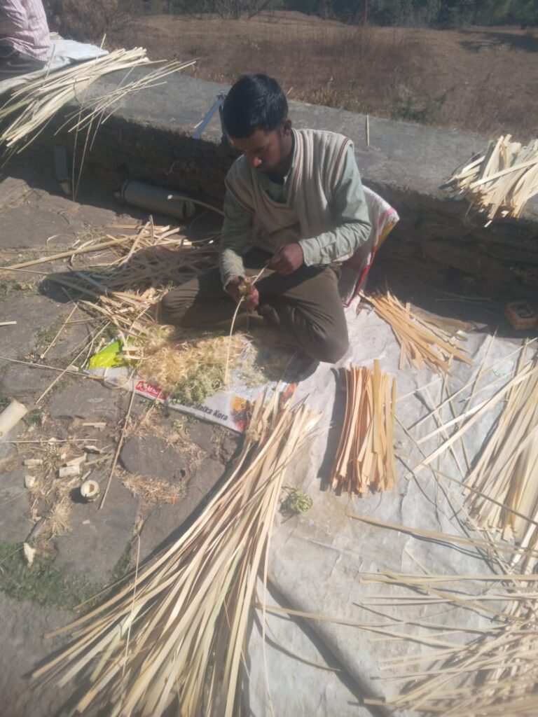 A craftsman weaving from individual strands of bamboo
